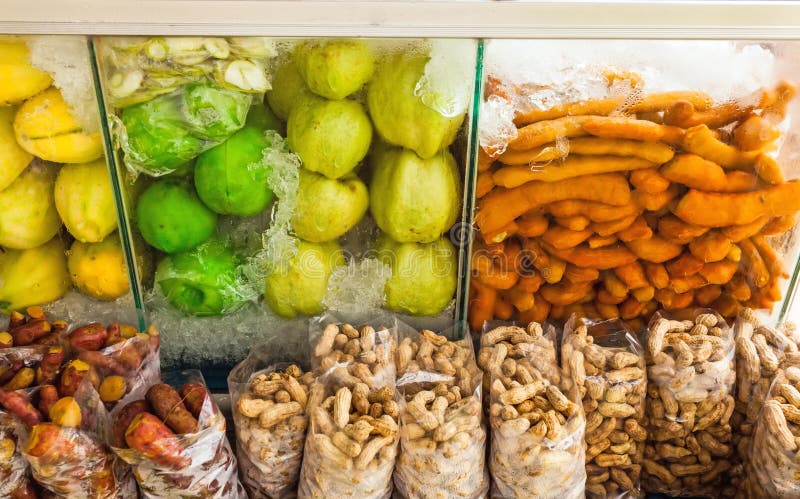 Grupo de frutos frescos e de conserva (manga, goiaba, tamarindo, feijão, 'batata doce') na caixa de armazenamento frio no mercado fotografia de stock Grupo de frutos frescos e de conserva (manga, goiaba, tamarindo, feijão, 'batata doce') na caixa de armazenamento frio no mercado fotografia de stock