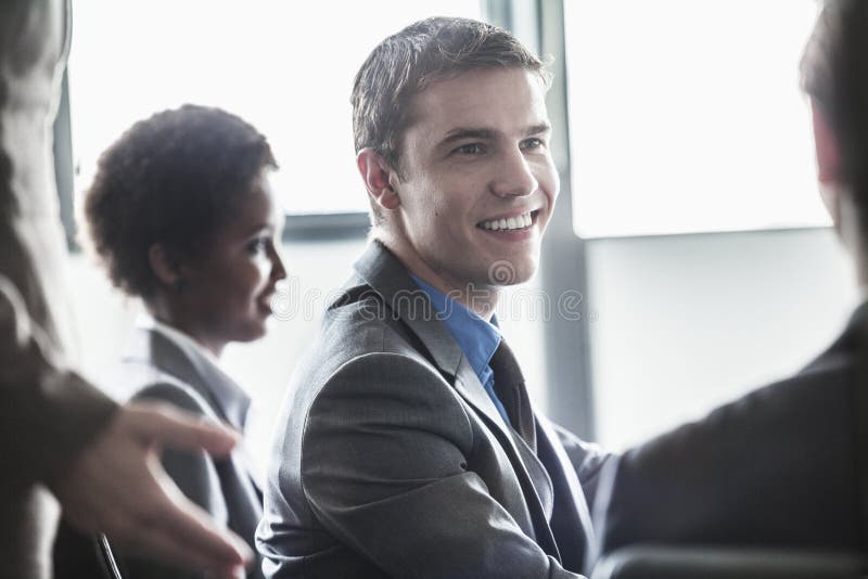 Grupo de hombres de negocios que se sientan y que sonríen en una reunión de negocios imagen de archivo Grupo de hombres de negocios que se sientan y que sonríen en una reunión de negocios imagen de archivo