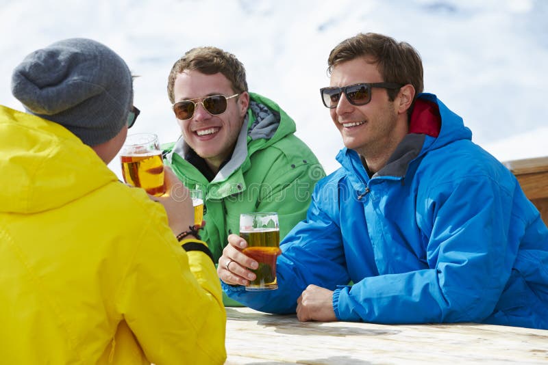 Grupo de hombres jovenes que disfrutan de la bebida en barra en Ski Resort foto de archivo libre de regalías Grupo de hombres jovenes que disfrutan de la bebida en barra en Ski Resort foto de archivo libre de regalías