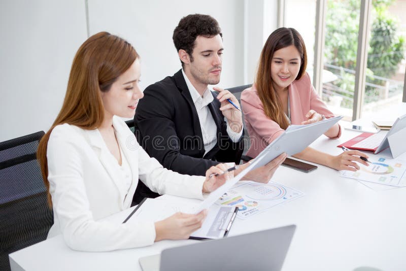 Grupo de hombres de negocios felices de los hombres y mujer que trabajan así como fichero de documento de papel en sala de reunió foto de archivo Grupo de hombres de negocios felices de los hombres y mujer que trabajan así como fichero de documento de papel en sala de reunió foto de archivo