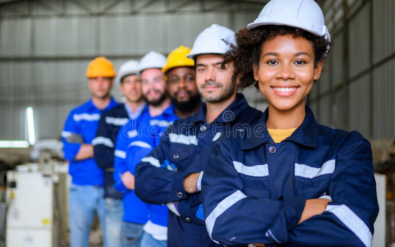 Grupo de ingenieros profesionales sonriendo a la cámara en la fábrica imagen de archivo libre de regalías