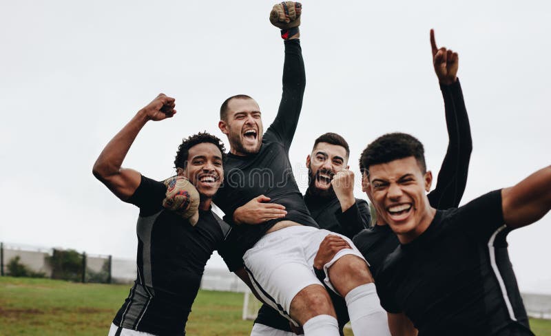 Grupo de jugadores de fútbol felices que celebran un triunfo levantando a su portero Futbolistas que celebran la victoria aumenta