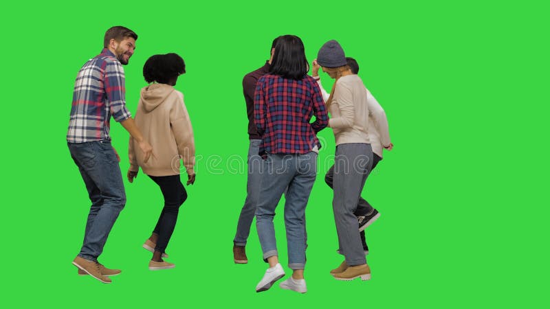 Grupo de jóvenes felices bailando juntos en una llave croma de pantalla verde.