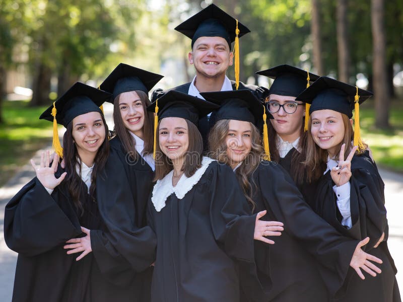 Group of happy graduates in robes outdoors. Group of happy graduates in robes outdoors