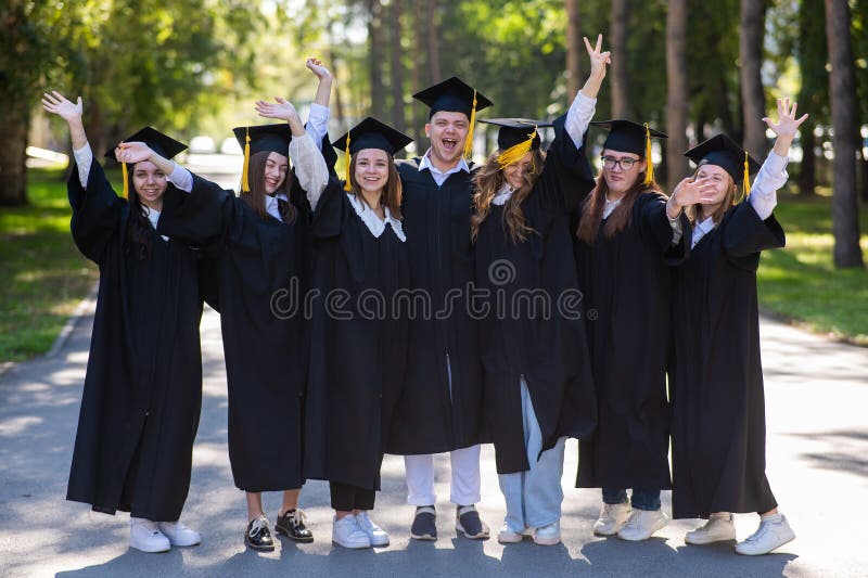 Group of happy graduates in robes outdoors. Group of happy graduates in robes outdoors