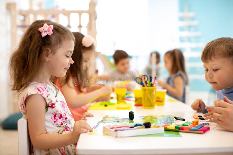 Grupo de los niños que aprende artes y artes en sala de juegos con interés fotos de archivo libres de regalías