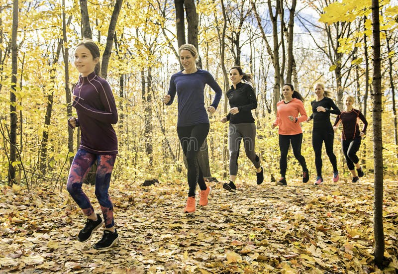 Grupo de mujeres corriendo juntas en un parque otoñal administran una carrera o un tren en un concepto de estilo de vida saludable fotografía de archivo libre de regalías
