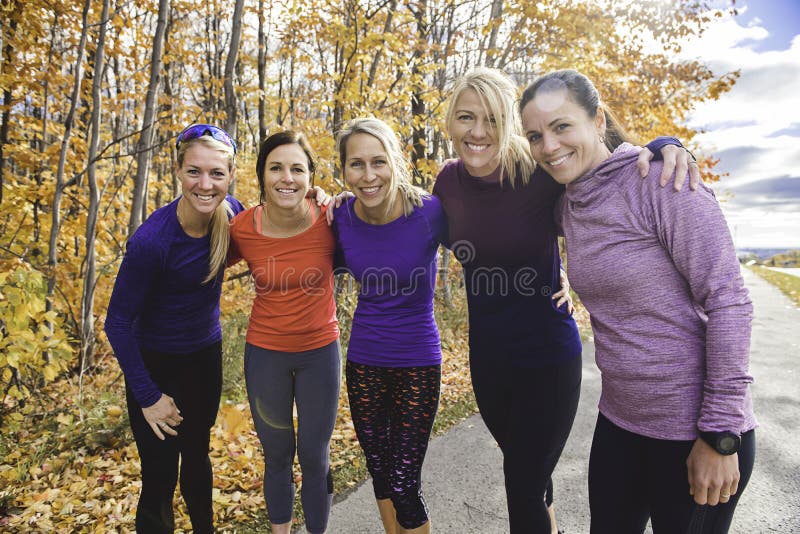 Grupo de mujeres corriendo juntas en un parque otoñal administran una carrera o un tren en un concepto de estilo de vida saludable foto de archivo
