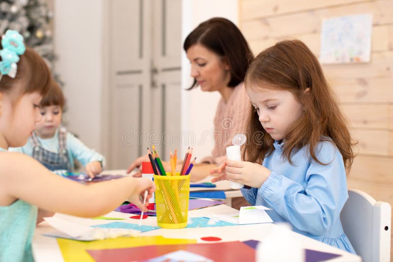 Grupo de niños en clases en jardines de infancia El profesor ayuda a los niños a trabajar Actividades preescolares en clase foto de archivo libre de regalías Grupo de niños en clases en jardines de infancia El profesor ayuda a los niños a trabajar Actividades preescolares en clase foto de archivo libre de regalías