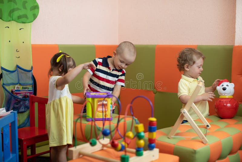 Grupo de niños que juegan en centro de la guardería o de guardería imágenes de archivo libres de regalías Grupo de niños que juegan en centro de la guardería o de guardería imágenes de archivo libres de regalías