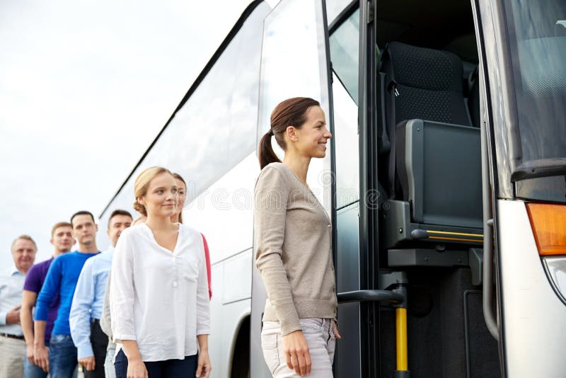 Transport, tourism, road trip and people concept - group of happy passengers boarding travel bus. Transport, tourism, road trip and people concept - group of happy passengers boarding travel bus