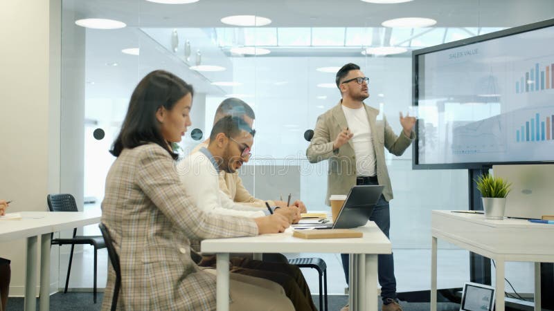 Grupo de personas que escuchan al jefe durante la reunión man está usando la pantalla digital para la presentación