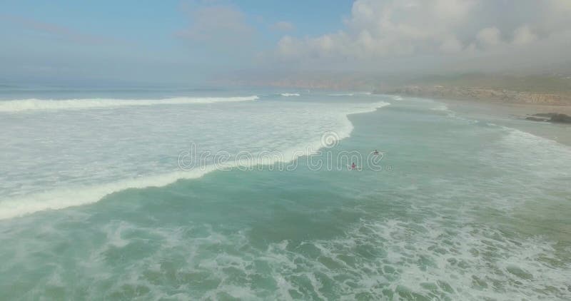 Grupo de personas que practica surf que cogen ondas