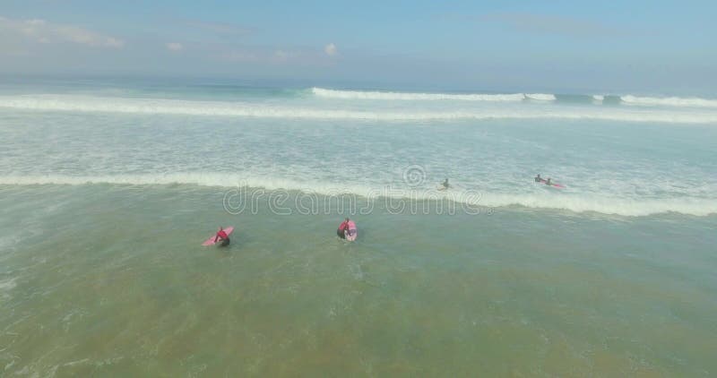 Grupo de personas que practica surf que cogen ondas