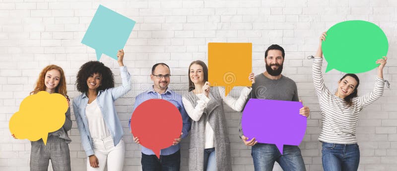 Global communications. Group of happy young diverse people holding empty colorful speech bubbles and smiling at camera. Global communications. Group of happy young diverse people holding empty colorful speech bubbles and smiling at camera