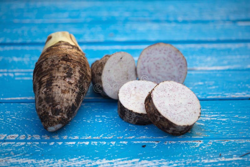 Grupo de Taro Root en fondo de madera foto de archivo