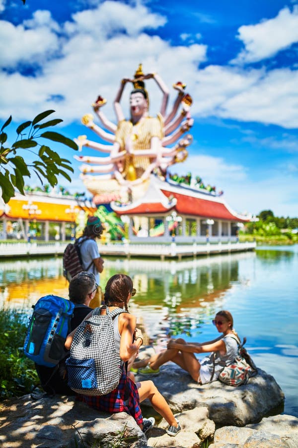 Grupo de turistas que descansam na máscara que olha o templo budista gigante em Tailândia foto de stock Grupo de turistas que descansam na máscara que olha o templo budista gigante em Tailândia foto de stock