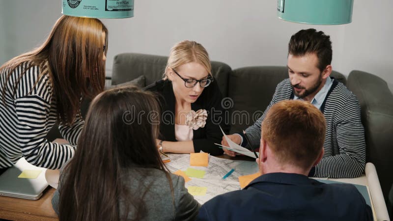 Grupo del intercambio de ideas de reunión creativa del equipo de la pequeña empresa de los arquitectos jovenes en oficina de lanz