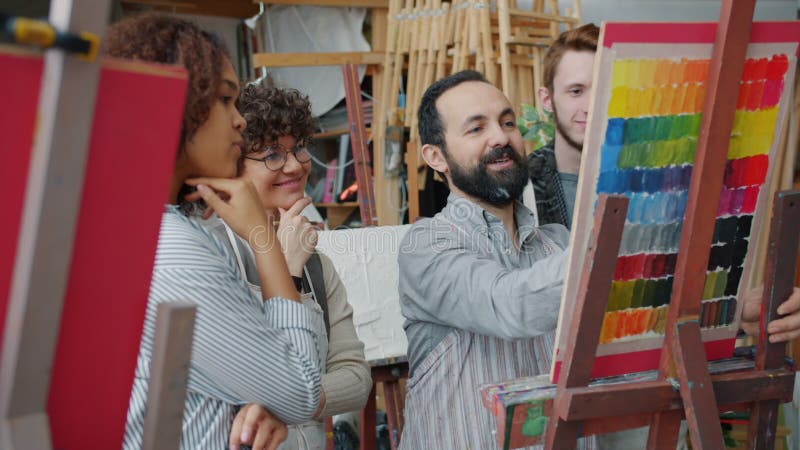 Grupo docente de pintores experimentados que dibujan y hablan con jóvenes