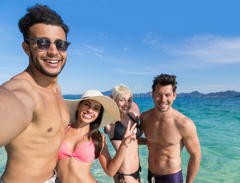 Grupo em férias de verão da praia, dois amigos de sorriso felizes dos jovens dos pares que tomam a foto de Selfie