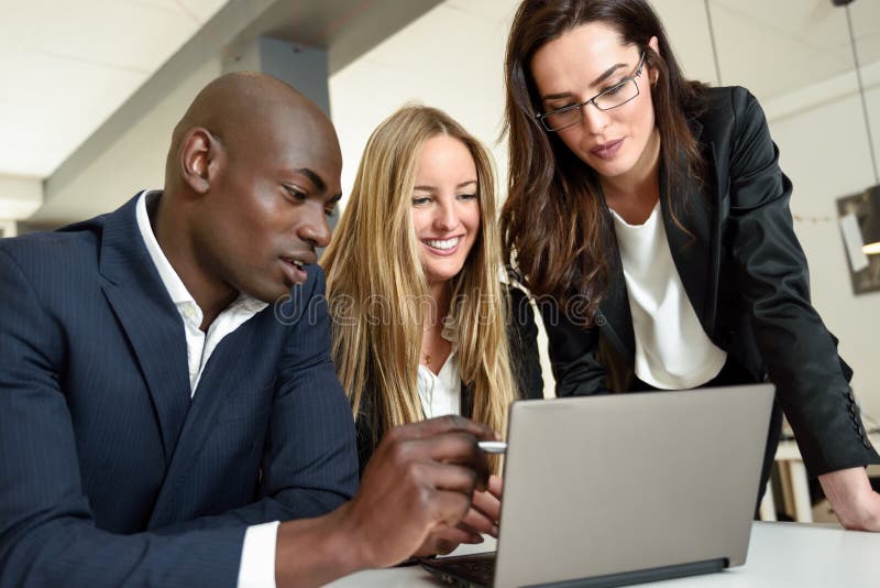 grupo Multi-étnico de três empresários que encontram-se em um o moderno foto de stock grupo Multi-étnico de três empresários que encontram-se em um o moderno foto de stock