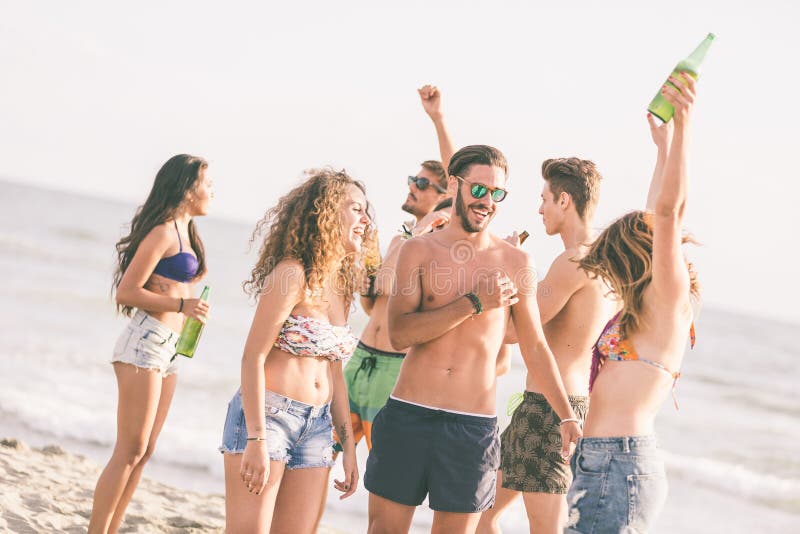 Grupo multirracial de amigos que tienen un partido en la playa imágenes de archivo libres de regalías Grupo multirracial de amigos que tienen un partido en la playa imágenes de archivo libres de regalías