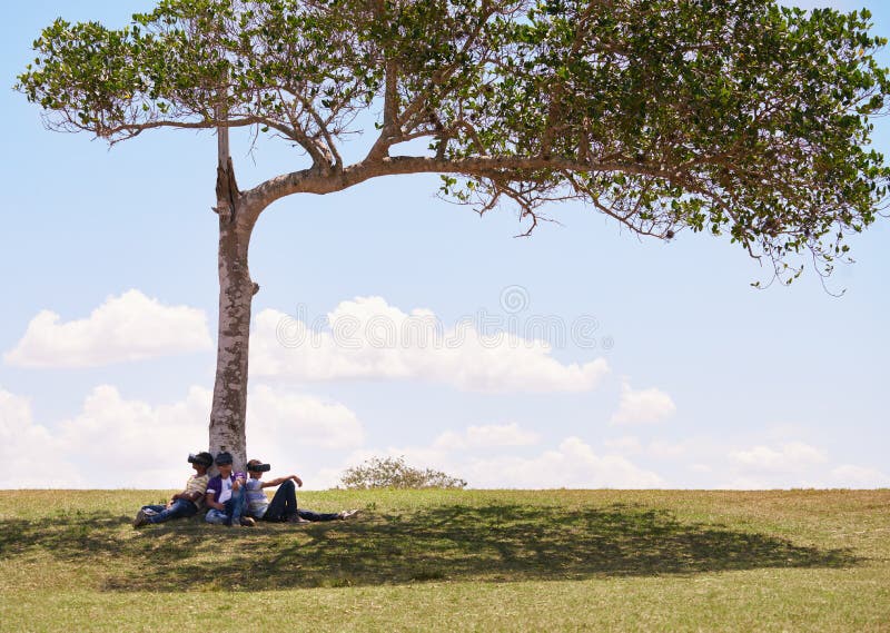 Grupo multiétnico de adolescentes que juegan realidad virtual en parque imagen de archivo libre de regalías Grupo multiétnico de adolescentes que juegan realidad virtual en parque imagen de archivo libre de regalías