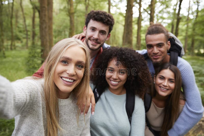 Grupo étnico multi de cinco amigos adultos jovenes que toman un selfie en un bosque durante un alza, retrato foto de archivo libre de regalías Grupo étnico multi de cinco amigos adultos jovenes que toman un selfie en un bosque durante un alza, retrato foto de archivo libre de regalías