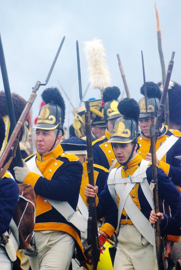 Group portrait of men marching with guns and wearing vintage military uniform. They are reenactors participating in Borodino historical reenactment battle at its 200th anniversary on September 02, 2012 in Borodino, Moscow Region, Russia. Group portrait of men marching with guns and wearing vintage military uniform. They are reenactors participating in Borodino historical reenactment battle at its 200th anniversary on September 02, 2012 in Borodino, Moscow Region, Russia.