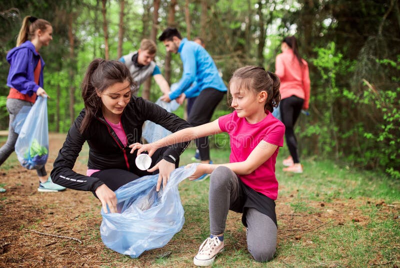 Grupp av aktivt folk som upp väljer kull i naturen, ett plogging begrepp royaltyfri foto Grupp av aktivt folk som upp väljer kull i naturen, ett plogging begrepp royaltyfri foto