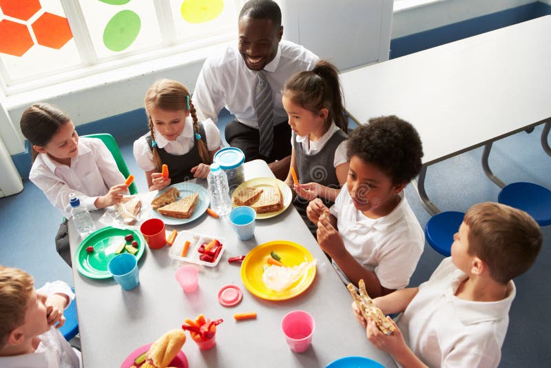 Grupp av barn som äter lunch i skolakafeteria arkivfoto Grupp av barn som äter lunch i skolakafeteria arkivfoto