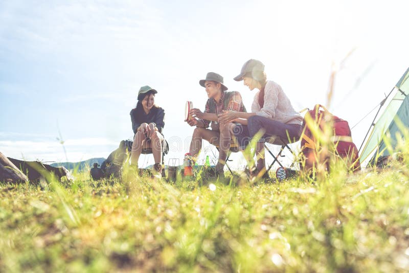 Grupp av handelsresande som campar och g? r picknicken i? ngf? ltf? rgrund Berg- och sj? bakgrund Folk och livsstilar royaltyfri foto