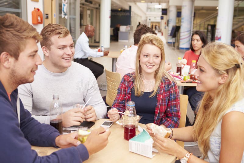 Grupp av högskolestudenter som tillsammans äter lunch arkivfoto Grupp av högskolestudenter som tillsammans äter lunch arkivfoto