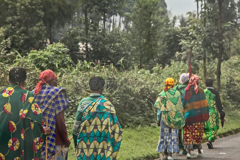 Grupp av lantliga rwandiska kvinnor i färgrik traditionalskläder som promenerar vägen, Kigali, Rwanda arkivbild Grupp av lantliga rwandiska kvinnor i färgrik traditionalskläder som promenerar vägen, Kigali, Rwanda arkivbild