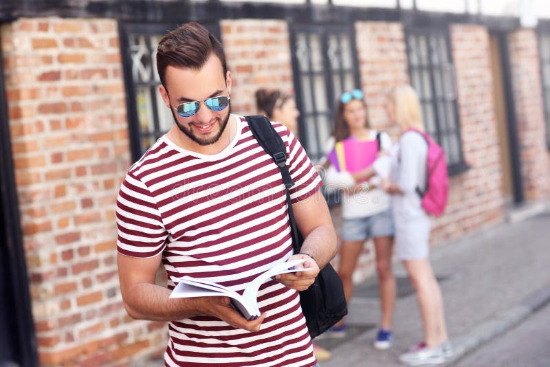Grupp av lyckliga studenter som utomhus studerar fotografering för bildbyråer