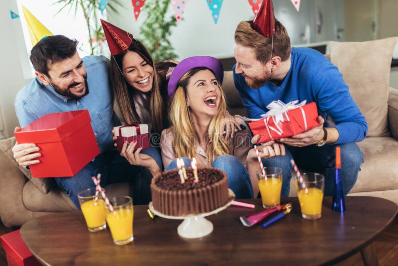 Grupp av lyckliga v?nner som hemma firar f?delsedag och har gyckel arkivfoto Grupp av lyckliga v?nner som hemma firar f?delsedag och har gyckel arkivfoto