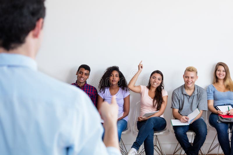 Group of multi ethnic students listening to teacher at university. Group of multi ethnic students listening to teacher at university