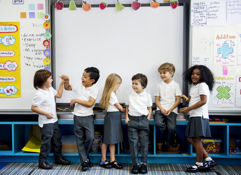 Diverse kindergarten students standing together in classroom. Diverse kindergarten students standing together in classroom