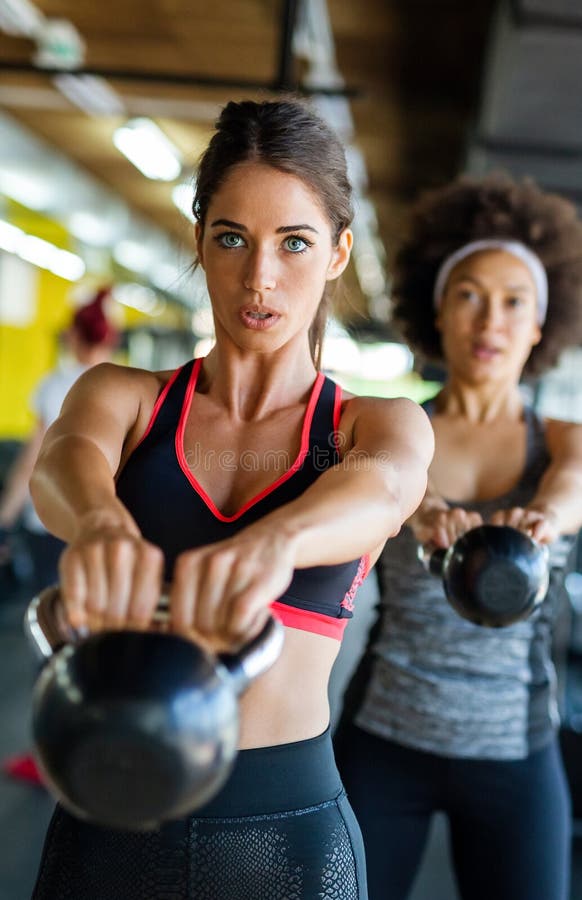 Grupp av passande personer som lyfter provdockor under en övningsklass på gymmet royaltyfri foto