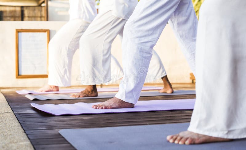 Grupp av pensionärer som öva yoga i morgonen arkivbild Grupp av pensionärer som öva yoga i morgonen arkivbild