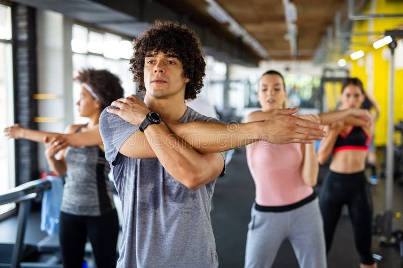 Grupp av personer som arbetar på gymmet. Multirasistiska vänner som tränar tillsammans i fitnessklubben. arkivfoto