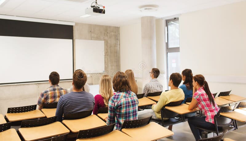 Education, high school, teamwork and people concept - group of students sitting in lecture hall from back. Education, high school, teamwork and people concept - group of students sitting in lecture hall from back