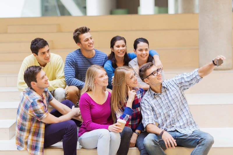 Grupp av studenter med smartphone- och kaffekoppen royaltyfri fotografi Grupp av studenter med smartphone- och kaffekoppen royaltyfri fotografi