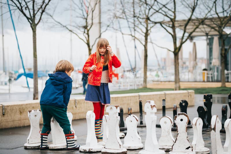Grupp av två ungar som spelar jätte- schack på lekplats royaltyfria foton Grupp av två ungar som spelar jätte- schack på lekplats royaltyfria foton
