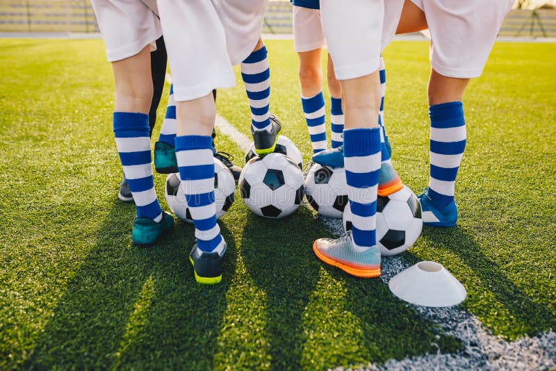 Grupp av unga fotbollsspelare på fotbollutbildning Ben av fotbollungar som sparkar bollar på fält arkivbilder Grupp av unga fotbollsspelare på fotbollutbildning Ben av fotbollungar som sparkar bollar på fält arkivbilder