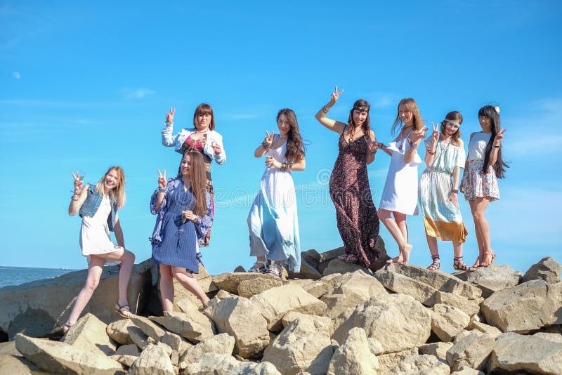 Grupp av unga kvinnors anseende tillsammans på en strand på en sommardag Lyckliga ungdomarsom tycker om en dag på stranden royaltyfri foto Grupp av unga kvinnors anseende tillsammans på en strand på en sommardag Lyckliga ungdomarsom tycker om en dag på stranden royaltyfri foto