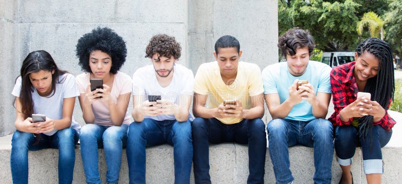 Group of young adults playing online game with phone outdoor in the summer. Group of young adults playing online game with phone outdoor in the summer