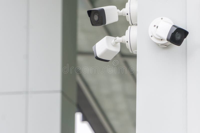 Grupp av yttersidan för CCTV-säkerhetskameror på den moderna byggande väggen i stad royaltyfri bild Grupp av yttersidan för CCTV-säkerhetskameror på den moderna byggande väggen i stad royaltyfri bild