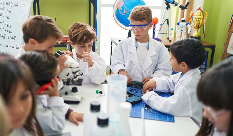 Grupp med barnstudenter som pratar om smartphone-reparationsgadget i laboratorieklassrum royaltyfri foto