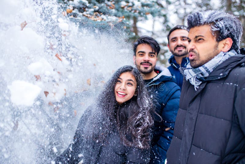 Grupp med fyra indianer som har kul att leka i snö utomhus och tillbringa helgdagar arkivbild